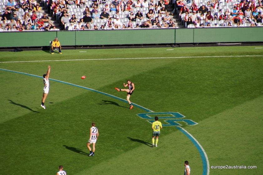 One of the players is kicking from inside the Fifty (a semi-circle with a radius of 50 meters from the goal posts) to get the ball between the two tall posts.