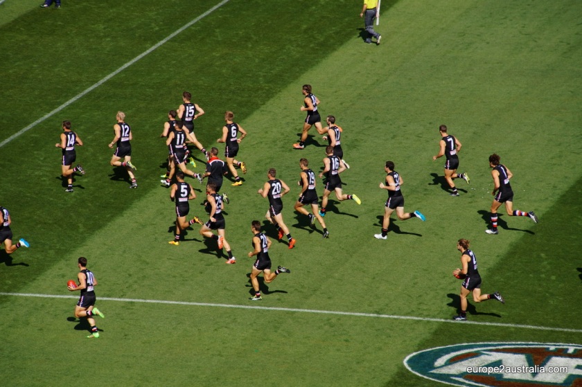 St. Kilda takes to the field, playing in black as the home team. (For today, the MCG is their "home". But this changes.)